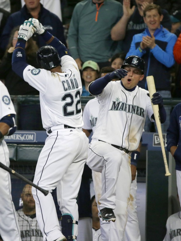 Seattle Mariners' Robinson Cano (22) celebrates at the dugout with' Kyle Seager, right, after Cano hit a solo home run in the fifth inning of a baseball game against the Texas Rangers, Wednesday, April 13, 2016, in Seattle. (AP Photo/Ted S. Warren)