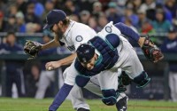 Mariners pitcher Wade Miley collides with catcher Chris Iannetta in Seattle's 8-0 loss to Texas. (AP)