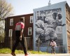 People pass by a Philadelphia Mural Arts Program mural of Jackie Robinson in Philadelphia on Friday, April 15, 2016. On Jackie Robinson Day, Philadelphia is acknowledged its racist treatment of the baseball pioneer when he played in the city nearly 70 years ago. City leaders issued an official apology in March, and highlighted its official apology during a ceremony Friday, also honoring Moses Fleetwood Walker, the first black Major League player. (AP Photo/Matt Rourke)