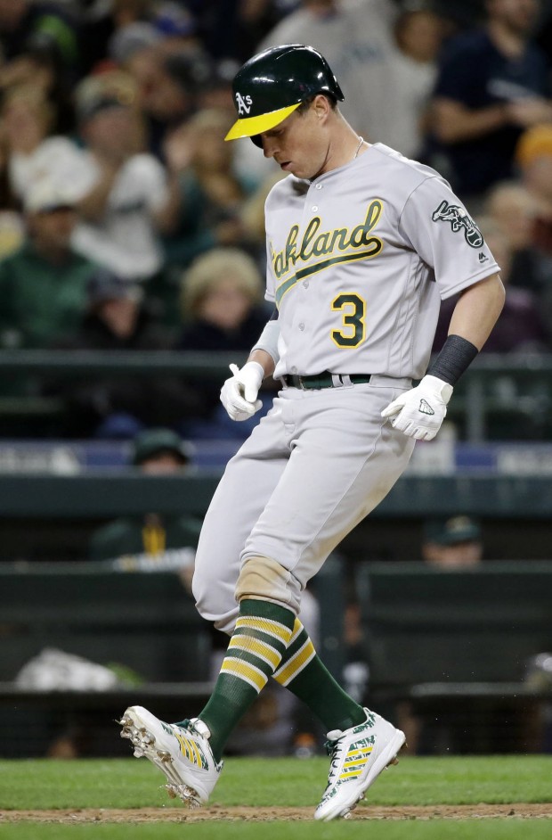 Oakland Athletics' Chris Coghlan touches home on his home run druing the ninth inning of a baseball game against the Seattle Mariners on Friday, April 8, 2016, in Seattle. (AP Photo/Elaine Thompson)