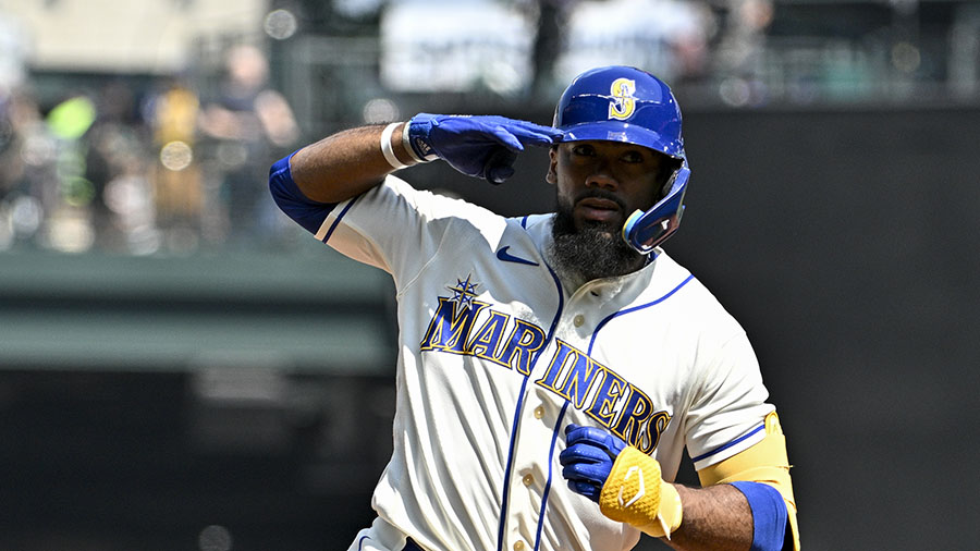 Seattle Mariners' Teoscar Hernandez in the dugout holding the