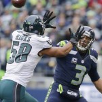 Seattle Seahawks quarterback Russell Wilson, right, throws a touchdown pass past Philadelphia Eagles middle linebacker Jordan Hicks (58) to hit Seahawks tight end Jimmy Graham (not shown) in the first half of an NFL football game, Sunday, Nov. 20, 2016, in Seattle. (AP Photo/John Froschauer)