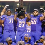 Boise State offensive linesman Rees Odhiambo (71), running back Jay Ajayi (27), and offensive linesman Mario Yakoo (66) hold the trophy after winning the Mountain West Conference championship NCAA college football game against Fresno State in Boise, Idaho, on Saturday, Dec. 6, 2014. Boise State won 28-14. (AP Photo/Otto Kitsinger)