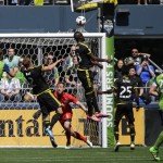 Columbus Crew's Kei Kamara, center, leaps high to head the ball away from the goal as Crew goalkeeper Steve Clark, third from left, and Seattle Sounders forward Jordan Morris, left, look on in the first half of an MLS soccer match, Saturday, April 30, 2016, in Seattle. (AP Photo/Ted S. Warren)