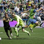 Seattle Sounders goalkeeper Stefan Frei, second from left, and Columbus Crew's Ethan Finlay, left, go for the ball as Sounders' Chad Marshall, right, jumps behind them, in the first half of an MLS soccer match, Saturday, April 30, 2016, in Seattle. (AP Photo/Ted S. Warren)