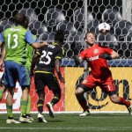 Columbus Crew goalkeeper Steve Clark, right, eyes the ball as he makes a save in the first half of an MLS soccer match against the Seattle Sounders, Saturday, April 30, 2016, in Seattle. (AP Photo/Ted S. Warren)