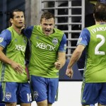 Seattle Sounders' Jordan Morris, center, celebrates with teammates Nelson Valdez, left, and Andreas Ivanschitz (23) after Morris scored a goal against the Philadelphia Union during the second half of an MLS soccer match, Saturday, April 16, 2016, in Seattle. The goal was Morris' first career MLS goal, and the Sounders beat the Union 2-1. (AP Photo/Ted S. Warren)
