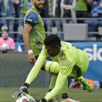 Philadelphia Union goalkeeper Andre Blake, right, dives to make a stop as Seattle Sounders midfielder Clint Dempsey watches during the first half of an MLS soccer match, Saturday, April 16, 2016, in Seattle. (AP Photo/Ted S. Warren)