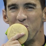
              United States' Michael Phelps kisses his gold medal after the men's 4x100-meter freestyle final during the swimming competitions at the 2016 Summer Olympics, Monday, Aug. 8, 2016, in Rio de Janeiro, Brazil. (AP Photo/Michael Sohn)
            