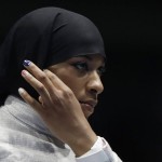 
              Ibtihaj Muhammad od the United States adjusts her hijab prior to competing with Olena Kravatska of Ukraine in the women's individual saber fencing event at the 2016 Summer Olympics in Rio de Janeiro, Brazil, Monday, Aug. 8, 2016. (AP Photo/Andrew Medichini)
            