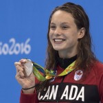 
              Canada's Penny Oleksiak shows off her silver medal from women's 100-meter butterfly at the 2016 Olympics Games in Rio de Janeiro on Sunday, Aug. 7, 2016. (Frank Gunn/The Canadian Press via AP)
            
