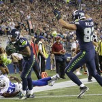 Seattle Seahawks wide receiver Tyler Lockett (16) scores a touchdown past Dallas Cowboys cornerback Anthony Brown, left, as Seahawks tight end Luke Willson signals the score at right, during the second half of a preseason NFL football game Thursday, Aug. 25, 2016, in Seattle. (AP Photo/Elaine Thompson)