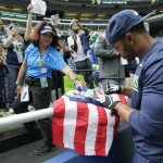 An usher helps Seattle Seahawks wide receiver Doug Baldwin sign an autograph for a fan before an NFL football game against the Miami Dolphins, Sunday, Sept. 11, 2016, in Seattle. (AP Photo/Elaine Thompson)