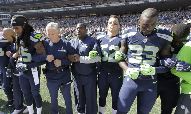 All Seahawks players and coaches stood with arms linked during the national anthem on Sunday. (AP)...