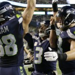 Seattle Seahawks quarterback Russell Wilson, center, celebrates with tight end Jimmy Graham (88) and offensive guard Mark Glowinski, right, after Wilson passed to Graham for a touchdown against the Buffalo Bills in the first half of an NFL football game, Monday, Nov. 7, 2016, in Seattle. (AP Photo/Elaine Thompson)