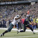 Seattle Seahawks quarterback Russell Wilson, right, scores a touchdown ahead of Philadelphia Eagles outside linebacker Nigel Bradham, left, after Wilson caught a pass from Seahawks' wide receiver Doug Baldwin in the second half of an NFL football game, Sunday, Nov. 20, 2016, in Seattle. (AP Photo/John Froschauer)