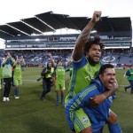 Seattle Sounders defender Roman Torres, top, is given a ride by forward Herculez Gomez as they celebrate with teammates after defeating the Colorado Rapids in the second leg of the MLS Western Conference soccer finals Sunday, Nov. 27, 2016, in Commerce City, Colo. (AP Photo/David Zalubowski)