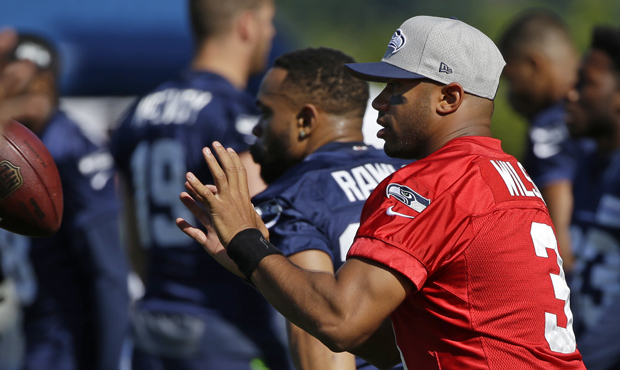 Seattle Seahawks quarterback Russell Wilson catches a ball tossed to him during a warm-up drill at ...