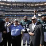 
              Philadelphia Eagles players, owner Jeffrey Lurie, center right, Eagles' President Don Smolenski, second from left, and a Philadelphia police officer, third from left, stand for the national anthem before an NFL football game against the New York Giants, Sunday, Sept. 24, 2017, in Philadelphia. Eagles' Malcolm Jenkins raises his fist next to Lurie. (AP Photo/Matt Rourke)
            