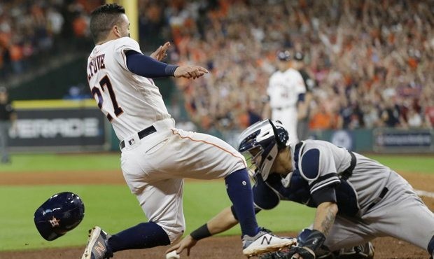 Houston Astros' Jose Altuve scores the game-winning run past New York Yankees catcher Gary Sanchez ...