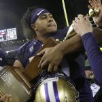 
              FILE - In this Nov. 25, 2017, file photo, Washington defensive lineman Vita Vea holds the Apple Cup trophy after Washington beat Washington State 41-14 in an NCAA college football game, in Seattle. Vea was selected to the AP All-Conference Pac-12 team announced Thursday, Dec. 7, 2017. (AP Photo/Ted S. Warren, File)
            