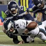Philadelphia Eagles quarterback Carson Wentz (11) fumbles the ball near the goal line and into the end zone as Seattle Seahawks' Earl Thomas (29) and Sheldon Richardson (91) move in during the second half of an NFL football game, Sunday, Dec. 3, 2017, in Seattle. (AP Photo/John Froschauer)