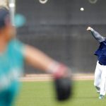 Seattle Mariners starting pitcher Hisashi Iwakuma, right, throws in the outfield during a baseball spring training workout, Monday, Feb. 19, 2018, in Peoria, Ariz. (AP Photo/Charlie Neibergall)