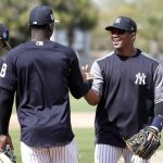 Seattle Seahawks NFL football team quarterback Russell Wilson, right, shakes hands with shortstop Didi Gregorius (18) at New York Yankees baseball spring training camp, Monday, Feb. 26, 2018, in Tampa, Fla.  (AP Photo/Lynne Sladky)