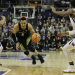 Oregon guard Elijah Brown drives between Washington guards Matisse Thybulle, left, and Jaylen Nowell, right, during the second half of an NCAA college basketball game, Saturday, March 3, 2018, in Seattle. Oregon won 72-64. (AP Photo/Ted S. Warren)