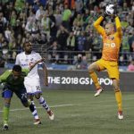 Montreal Impact goalkeeper Evan Bush, right, leaps to make a stop during the second half of an MLS soccer match against the Seattle Sounders, Saturday, March 31, 2018, in Seattle. The Impact won 1-0. (AP Photo/Ted S. Warren)