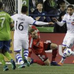Seattle Sounders goalkeeper Stefan Frei, second from right, goes down as Montreal Impact forward Jeisson Vargas (16) moves in to kick a goal during the second half of an MLS soccer match, Saturday, March 31, 2018, in Seattle. The Impact won 1-0. (AP Photo/Ted S. Warren)