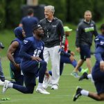 Seattle Seahawks head coach Pete Carroll, center, walks as players stretch during NFL football practice, Thursday, May 24, 2018, in Renton, Wash. (AP Photo/Ted S. Warren)