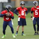 Seattle Seahawks quarterback Russell Wilson, left, drops to pass as backups Austin Davis (6) and Alex McGough (5) look on during NFL football practice, Thursday, May 24, 2018, in Renton, Wash. (AP Photo/Ted S. Warren)