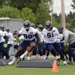 From left, Seattle Seahawks linebacker Bobby Wagner (54) defensive tackle Jarran Reed (90) and defensive tackle Tom Johnson (91) take part in an agility drill during NFL football practice, Thursday, May 24, 2018, in Renton, Wash. (AP Photo/Ted S. Warren)