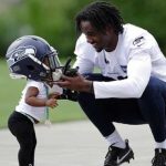 Seahawks rookie CB Tre Flowers visits with his daughter after minicamp. (AP)