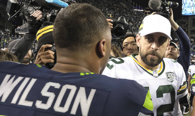 Seattle Seahawks quarterback Russell Wilson, left, greets Green Bay Packers quarterback Aaron Rodge...