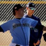 Seattle Mariners manager Scott Servais watches while pitcher Erik Swanson throws during spring training baseball practice Tuesday, Feb. 12, 2019, in Peoria, Ariz. (AP Photo/Charlie Riedel)