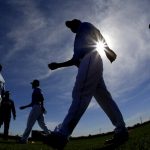 Seattle Mariners pitcher Yusei Kikuchi, center, from Japan, walks to a practice field during spring training baseball practice, Tuesday, Feb. 12, 2019, in Peoria, Ariz. (AP Photo/Charlie Riedel)
