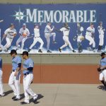Seattle Mariners players walk to a practice field during spring training baseball practice Tuesday, Feb. 12, 2019, in Peoria, Ariz. (AP Photo/Charlie Riedel)