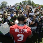 Seattle Seahawks quarterback Russell Wilson (3) signs autographs for fans following NFL football training camp, Thursday, July 25, 2019, in Renton, Wash. (AP Photo/Ted S. Warren)