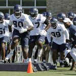Seattle Seahawks defensive tackle Jarran Reed (90) runs a drill with teammates during NFL football training camp, Thursday, July 25, 2019, in Renton, Wash. (AP Photo/Ted S. Warren)