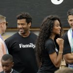From left to right, hip-hop artist Macklemore, Seattle Seahawks NFL football quarterback Russell Wilson, Wilson's wife, pop singer Ciara, and former Microsoft executive Terry Myerson visit Monday, Aug. 19, 2019, during an event in Seattle held to introduce themselves and others as new members of the MLS soccer Seattle Sounders team's ownership group. (AP Photo/Ted S. Warren)