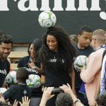 Pop singer Ciara, center, the wife of Seattle Seahawks NFL football quarterback Russell Wilson, left, heads a soccer ball, Monday, Aug. 19, 2019, during an event in Seattle held to introduce the couple, hip-hop artist Macklemore, and others as new members of the Seattle Sounders MLS soccer team's ownership group. (AP Photo/Ted S. Warren)