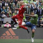 Toronto FC's Michael Bradley, left, and Seattle Sounders' Roman Torres battle for the ball Sunday, Nov. 10, 2019, during the first half of the MLS Cup championship soccer match in Seattle. (AP Photo/Elaine Thompson)