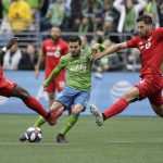 Seattle Sounders' Victor Rodriguez, center, kicks the ball to score between Toronto FC's Chris Mavinga, left, and Omar Gonzalez, Sunday, Nov. 10, 2019, during the second half of the MLS Cup championship soccer match in Seattle. (AP Photo/Ted S. Warren)