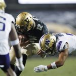 Colorado quarterback Steven Montez, center, is stopped after a short gain by Washington defensive back Myles Bryant, right, as defensive back Cameron Williams comes in to cover during the first half of an NCAA college football game Saturday, Nov. 23, 2019, in Boulder, Colo. (AP Photo/David Zalubowski)
