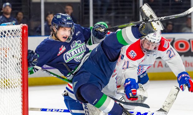 After being pushed in the back, Seattle's Henrik Rybinski collides with Spokane goalie Campbell Arn...