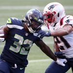 SEATTLE, WASHINGTON - SEPTEMBER 20: Adrian Phillips #21 of the New England Patriots attempts to tackle Chris Carson #32 of the Seattle Seahawks during the first quarter at CenturyLink Field on September 20, 2020 in Seattle, Washington. (Photo by Abbie Parr/Getty Images)