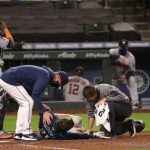 SEATTLE, WASHINGTON - SEPTEMBER 21: Dylan Moore #25 of the Seattle Mariners is attended to after being hit by pitch in the eighth inning against the Houston Astros at T-Mobile Park on September 21, 2020 in Seattle, Washington. (Photo by Abbie Parr/Getty Images)