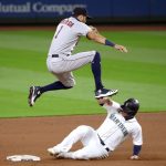 SEATTLE, WASHINGTON - SEPTEMBER 22: Carlos Correa #1 of the Houston Astros leaps over Ty France #23 of the Seattle Mariners after outing him at second base to end the fifth inning at T-Mobile Park on September 22, 2020 in Seattle, Washington. (Photo by Abbie Parr/Getty Images)